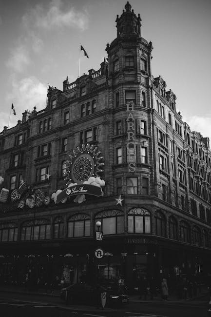 Exterior view of a historic building in Knightsbridge decorated for the holiday season with illuminated gold and white ornaments, stars, and festive banners. The building features intricate stonework,
