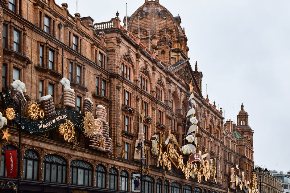 Close-up view of the upper corner of a historic brick building in Knightsbridge, featuring a large vertical sign spelling 'FEARGROUNDS' in illuminated letters. The building's facade includes decorativ